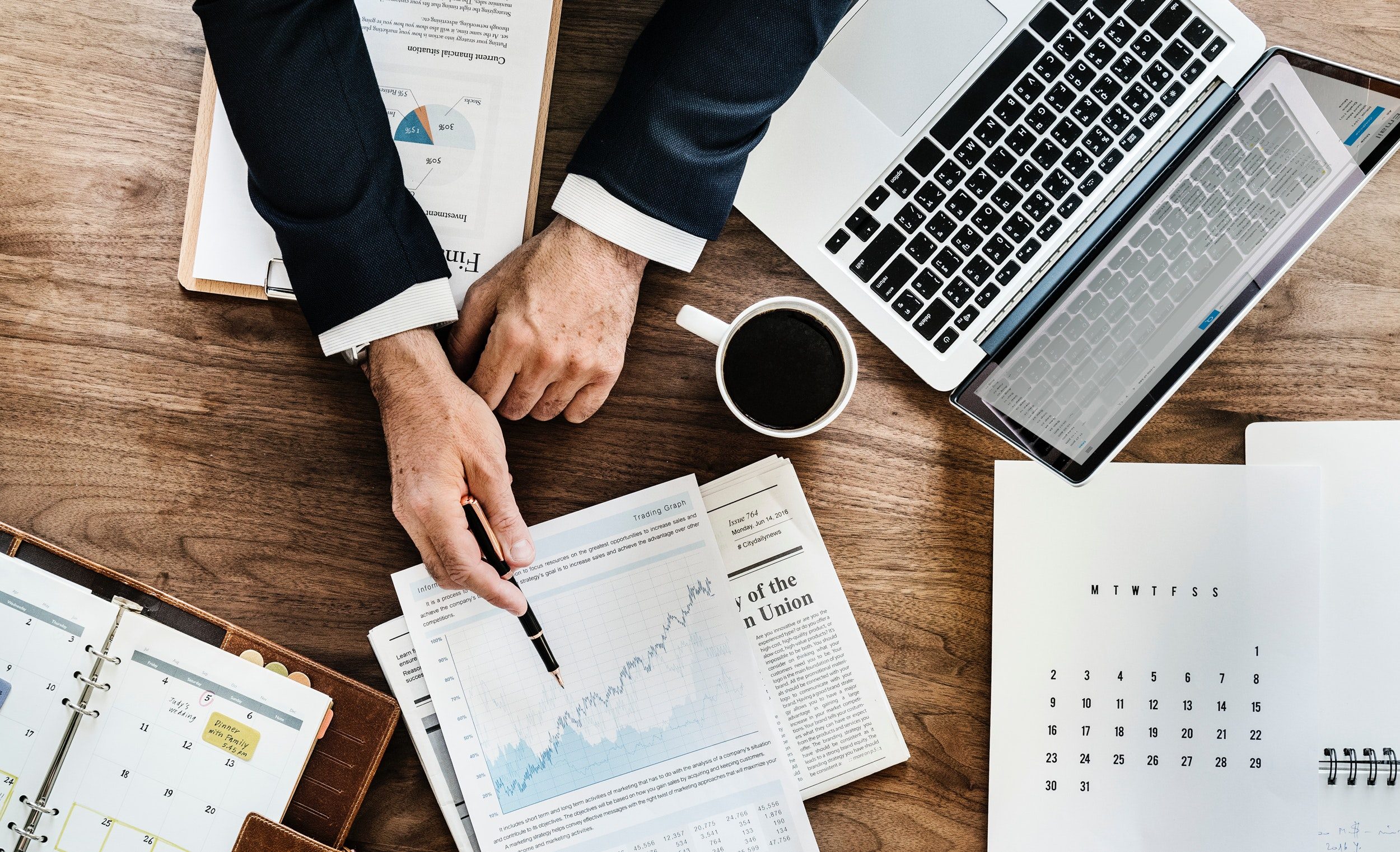 business man sitting at desk, hands to charts